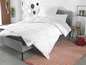 Une couette et des oreillers blancs de la marque Sannwald sur un lit.