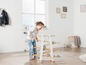 Un enfant joue avec une piste de billes en bois.