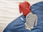 Twee babypakjes met lange mouwen, een gestreept en een rood met 'Go Wild' erop.
