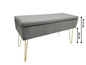 Banc de rangement en velours gris avec pieds dorés.