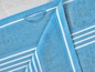 Een blauwe badhanddoek met witte strepen
