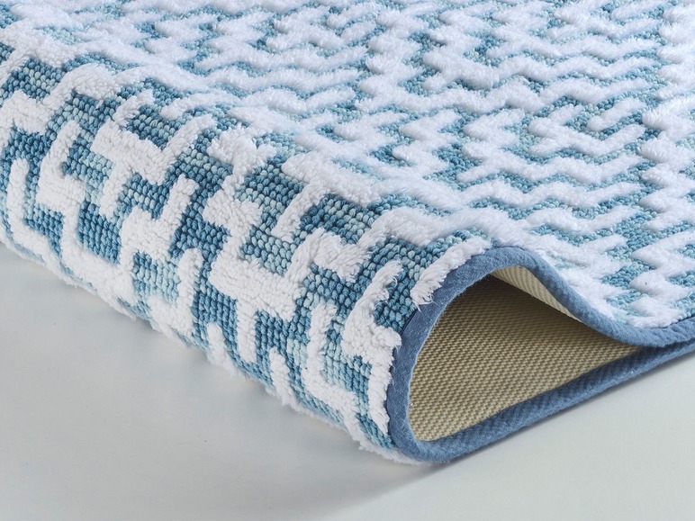 Tapis de salle de bain à motif chevron bleu et blanc.