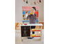 Un enfant joue avec un magasin de jouets en bois avec un tableau noir.