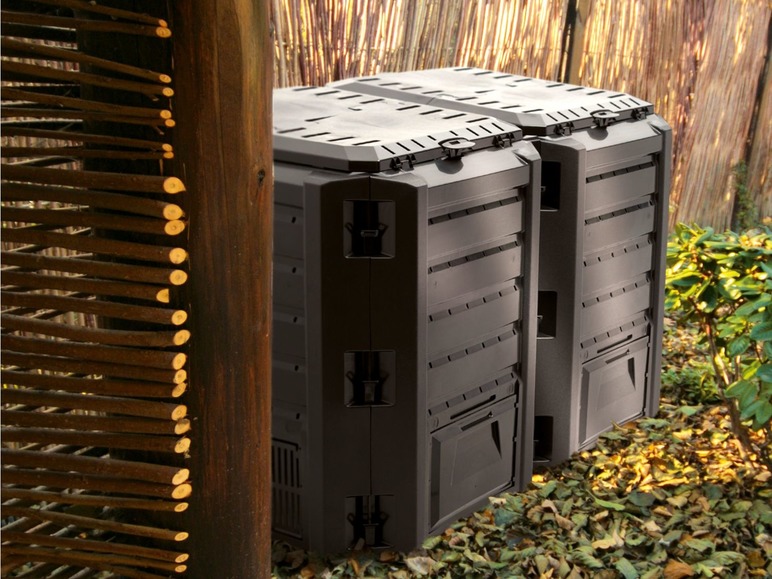 Twee zwarte compostbakken in de tuin