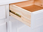 Een witte commode met een open lade, die een houten interieur laat zien.