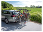 Een auto met een fietsendrager met vier fietsen.