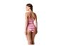 Femme en maillot de bain une pièce rose à motif zigzag, regardant par-dessus son épaule.