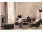 Salon avec canapé gris, fauteuil, pouf et commode en bois.
