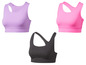 Drie sportbeha's in verschillende kleuren: paars, roze en zwart.