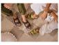 Quatre personnes en sandales à deux brides, assises sur un tapis à carreaux.