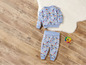 Un haut et un pantalon bleus pour bébé avec un imprimé arc-en-ciel et fleurs.