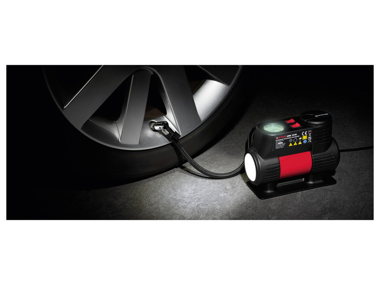 Une pompe à air pour pneus Ultimate UMK 10 E4 avec un tuyau relié à un pneu de voiture.