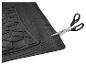 Tapis de voiture noir texturé, coupé avec des ciseaux.