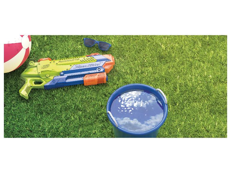 Pistolet à eau, ballon de plage, lunettes de soleil et seau d'eau sur l'herbe.