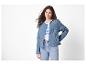 Femme en veste matelassée bleue, t-shirt blanc à texte et jean.