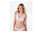 Femme en soutien-gorge et culotte blancs avec dentelle, souriante.