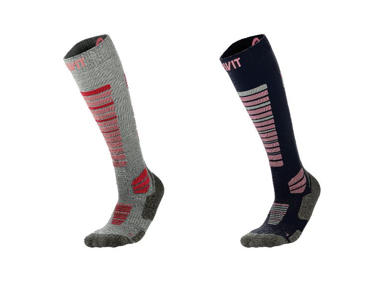 Deux paires de chaussettes de ski, une grise avec des accents rouges, une bleu marine avec des accents roses.