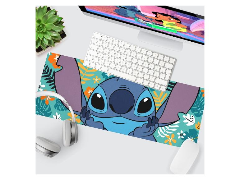 Tapis de bureau avec personnage de dessin animé bleu, clavier, souris et plante.