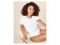 Vrouw in een wit T-shirt-bodysuit zittend op een stoel.