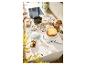 Garçon décorant des biscuits de Noël sur un comptoir de cuisine avec un gâteau et des fournitures de pâtisserie.