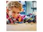 Een jongen speelt met een speelgoedpolitiewagen, een motorfiets en minifiguren op een houten tafel.