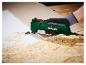 Een persoon gebruikt een Parkside oscillerende multitool om lijm van een houten oppervlak te verwijderen.