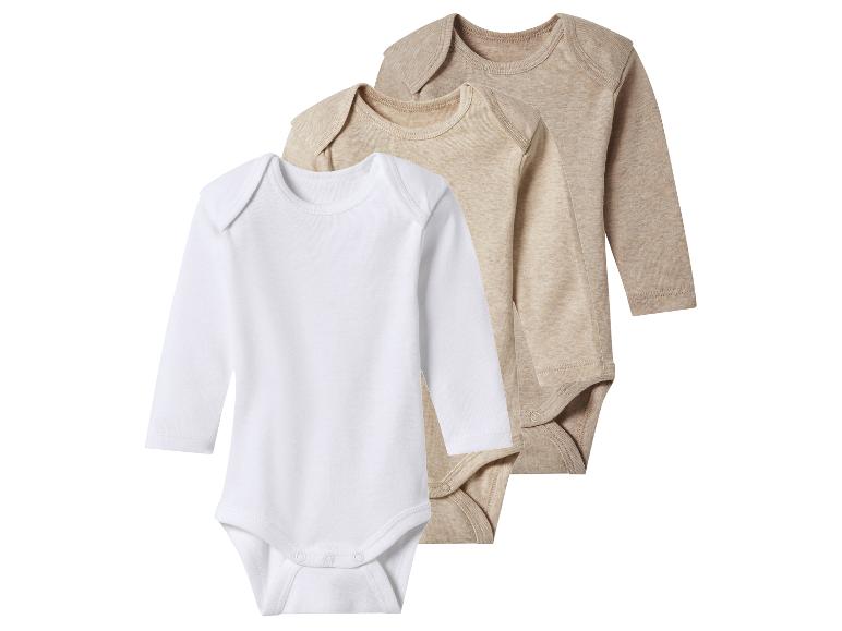 Drie rompertjes met lange mouwen in wit, lichtbeige en beige.