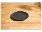 Assiette ronde gris foncé sur une table en bois clair.