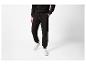 Personne en pantalon de survêtement et sweat-shirt noirs avec des baskets blanches.
