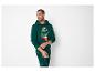 Man in een groene hoodie en bijpassende pyjamabroek met kerstboomprint.