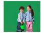 Twee blije kinderen in blauwe fleecevesten en regenbroeken, hand in hand en een groene emmer.