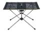 Table de camping pliable avec surface en maille noire et pieds métalliques.