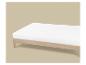 Lit en bois avec matelas blanc sur fond beige clair