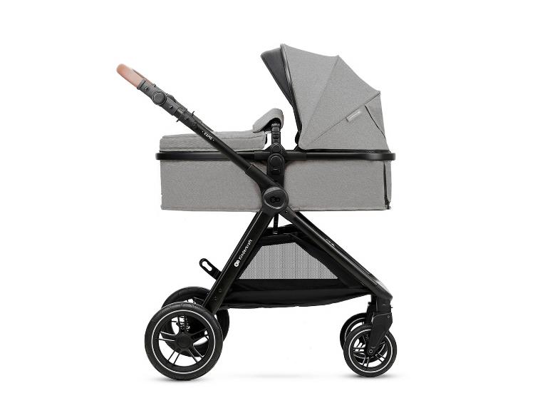 Poussette bébé grise avec nacelle et poignée marron, vue latérale.