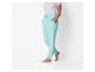 Vrouw in wit T-shirt en turquoise joggingbroek