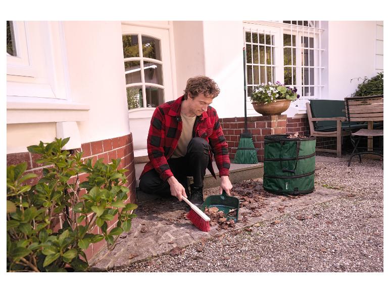 Un homme balaye des feuilles à l'extérieur avec le kit de balayage d'extérieur PARKSIDE®.