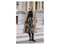 Vrouw in beige jas, zwarte trui en rok met zebraprint.