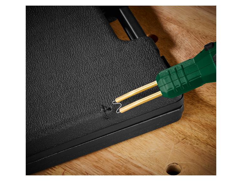 Kunststoflasapparaat met groene handgreep repareert een zwart oppervlak.