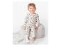 Un petit bébé assis sur un fauteuil avec un pyjama à manches longues à étoiles.