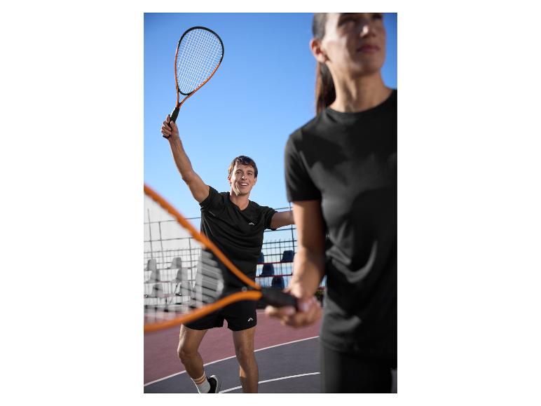 Twee mensen in zwarte sportkleding spelen padel op een buitenbaan.