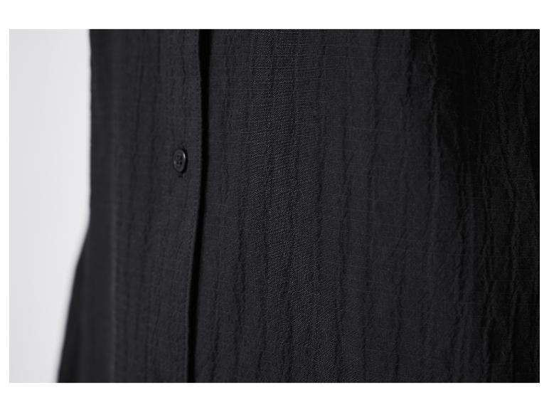 Gros plan sur une chemise noire boutonnée.