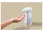 Een hand ontvangt zeep van een witte automatische zeepdispenser.