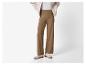 Pantalon marron large avec boutons dorés et baskets beiges.