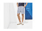 Man in gestreepte korte broek en witte sneakers