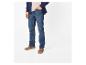 Homme en jean bleu, t-shirt beige et cardigan bleu marine avec des chaussures marron.