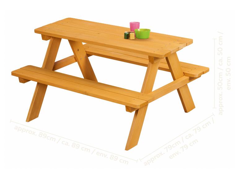 Table de pique-nique en bois pour enfants avec bancs et vaisselle colorée.
