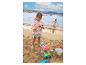 Twee kinderen spelen met strandspeelgoed, waaronder emmers, schepjes en een ijshoorntje, aan zee.