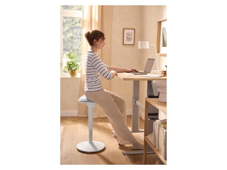 Femme utilisant LIVARNO® Stehhilfe à un bureau réglable avec un ordinateur portable.