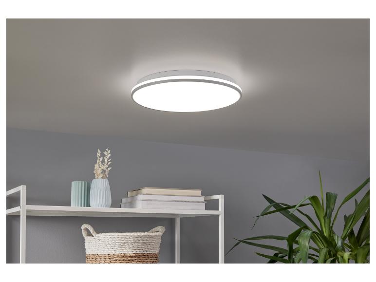 Een ronde plafondlamp met witte afwerking in een moderne kamer.