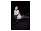 Femme en robe pull grise, collants rayés et bottes noires, assise sur une chaise.